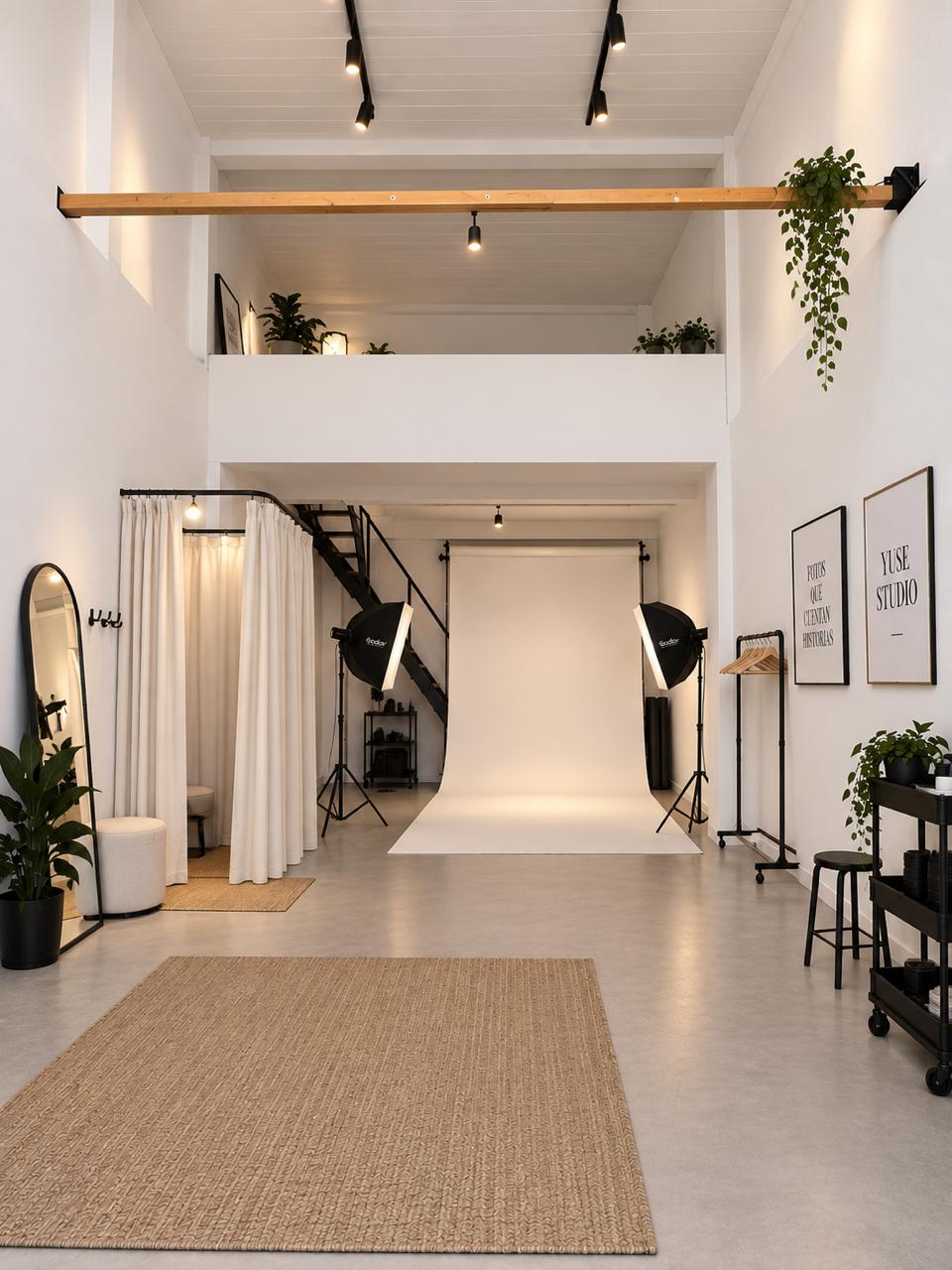 Interior del estudio YUSE, con fondo infinito blanco y equipamiento de iluminación profesional
